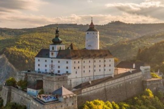 eine Burg mit großem Turm auf einem Hügel