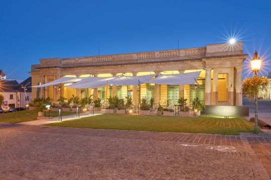 ein Gebäude mit Säulen, beleuchtet in der Dämmerung